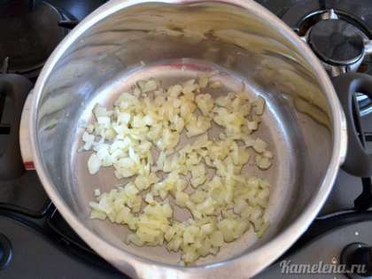 В кастрюлю с толстым дном положить сливочное масло, растопить. Выложить лук, обжарить в течение 3-5 минут до мягкости.