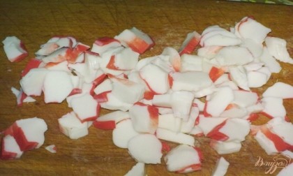 Крабовые палочки очистить от целлофана и нарезать кольцами. Крабовые палочки можно заменить крабовым мясом. Если используйте крабовое мясо, то режьте его соломкой.