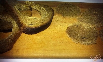 Хлеб нарезаем ломтиками и вырезаем из них кружки. Это можно сделать с помощью обычного стакана или специальной формочки. Если вы не любите черный хлеб, его можно заменить белым, будет тоже очень вкусно. Лучше всего для этой закуски подойдет Бородинский хлеб.