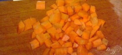 Морковь очистить и нарезать кубиками. Чтобы морковь была мягкой, ее нужно немного потушить. Для этого в сковороду долейте воды и потушите на слабом огне, пока вода не выкипит. Обжарить кубики моркови на масле две минуты.