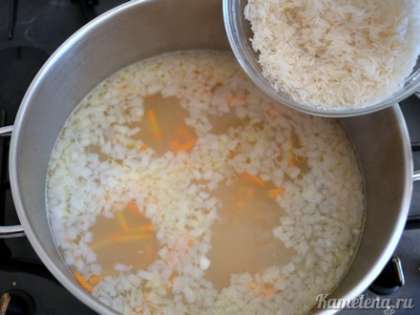 Добавить промытый рис, еще немного посолить, поперчить, перемешать. Варить суп примерно 20 минут (до готовности риса и картофеля).