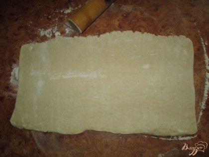 Пласт готового дрожжевого теста разморозить и раскатать на ровной поверхности, толщиной примерно 2-3 мм. Чтобы тесто не прилипало к рукам, можно посыпать его мукой.