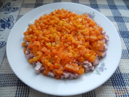 Затем выкладываем нарезанную морковь на слой колбасы.