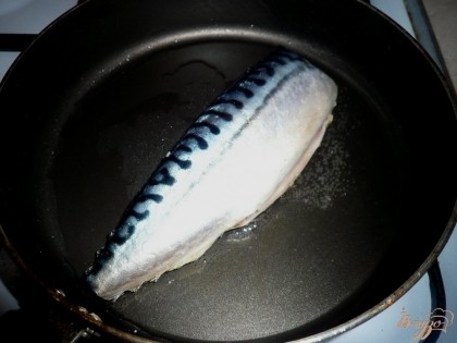 Разогреваем сковороду с небольшим количеством рафинированного растительного масла, затем выкладываем тушку скумбрии (я жарила целиком, но если удобнее, то стоит сразу порезать рыбу на порционные куски). Растительного масла надо совсем немного так как скумбрия рыба жирная.