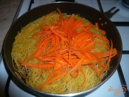 Морковь промываем, чистим, натираем на крупной терке или мелко нарезаем и добавляем в сковороду к обжаренной вермишели.