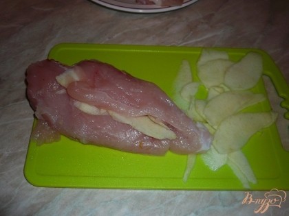 Затем закладываем дольки яблока между малым и большим филе грудки, можно дополнительно надрезать мясо.