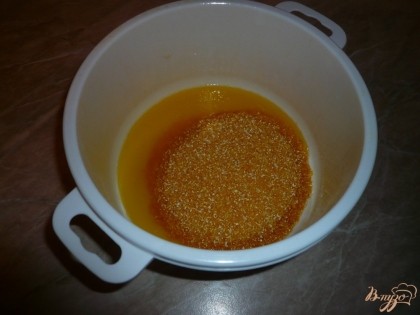 Добавляем кукурузную крупу к растопленному маргарину (сначала половину – один стаканчик, так легче перемешивать).