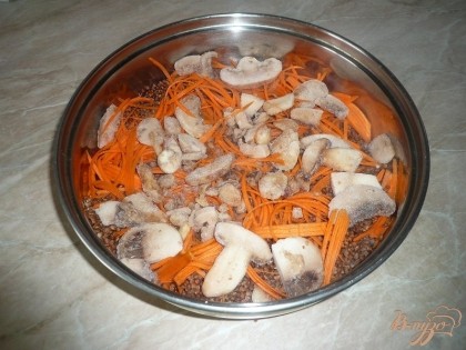 На морковь выкладываем шампиньоны. Свежие грибы промываем и нарезаем, замороженные же выкладываем прямо так, предварительно размораживать грибы не надо.