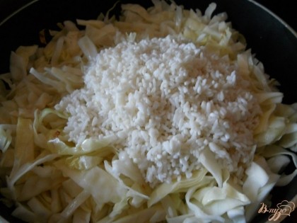 Далее в сковороду к капусте выкладываем промытый рис.