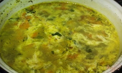 Зелень всыпьте в суп. Затем помешивая, тонкой струйкой влейте в суп взбитое яйцо. Проварите еще минуты и снимите с огня. Накройте крышкой и дайте настояться в течение 20 минут.