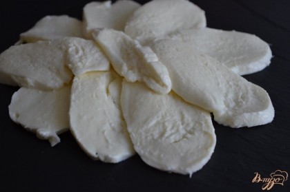 Сыр нарезать тонко  и выложить первым слоем на тарелку.