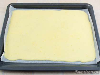 На противень постелить пекарскую бумагу. Выложить тесто, аккуратно размазать ровным слоем на всю площадь противня.