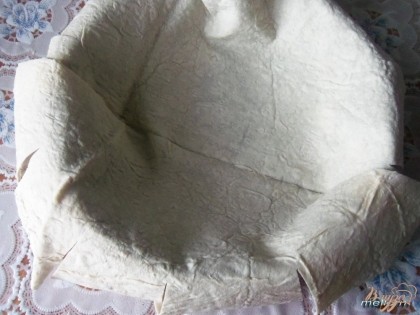 Из лаваша вырезать круг на 5-6 см больше формы, в которой будет готовиться пирог. Лаваш выложить в смазанную маслом форму.