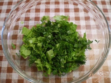 В салатник порезать листья салата и зелень.