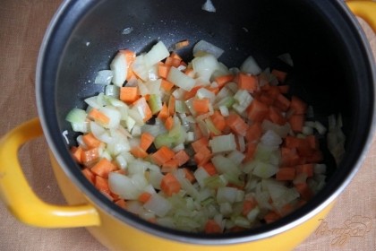 Лук, чеснок, сельдерей и морковь очистить, нарезать небольшими кубиками, пассеровать на разогретом оливковом масле, помешивая, около 10 мин.