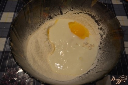 Приготовьте тесто для вареников. Для этого в большую миску просеять муку. Добавить соль. Перемешать. Вбейте 1 яйцо. Влейте кефир. Кефир можно брать любой жирности. Даже 1 процентный. Я часто готовлю на домашней простокваше. Из полученных продуктов замесите тесто.