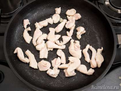 На сковороде на сильном огне разогреть немного растительного масла. Выложить половину курицы, жарить при активном перемешивании в течение пары минут, пока кусочки не побелеют со всех сторон.  Переложить курицу на тарелку, также обжарить вторую половину курицы.