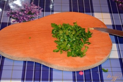 Для салата следует нарезать зелень. Лучше в салат использовать только листитки петрушки и укропа. В толстых стволах больше нетратов и они очень жесткие. Измельчите зелень ножом. Добавьте в салат. Чтоб зелень дала максимум аромата ее можно подавить широкой стороной ножа.