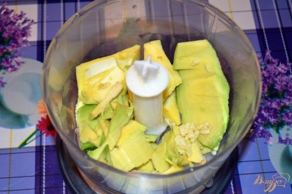 При помощи столовой ложки выньте мякоть авокадо из двух половинок. Сложите в чашу блендера.
