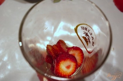 В подготовленные стаканы выложите нарезанные ягоды клубники.