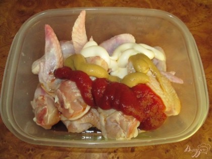 В отдельную посуду выложим куриные крылышки и зальем составляющими соуса.