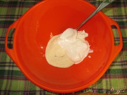 В миску насыпать несколько ложек манной крупы и добавить сметану.