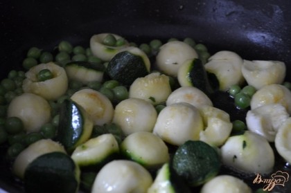 На сковороде , в  смеси оливкового и сливочного масла обжарить шарики цукини и зеленый горошек в течении 5 мин. В конце немного посолить.