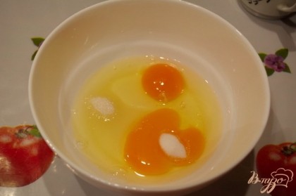 В мисочку вбейте 2 яйца. Добавьте соль и сахар. Добавьте разрыхлитель и взбейте.