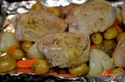 Затем выложим кусочки курицы на противень поверх овощей и поставим вновь в духовку до готовности курицы.