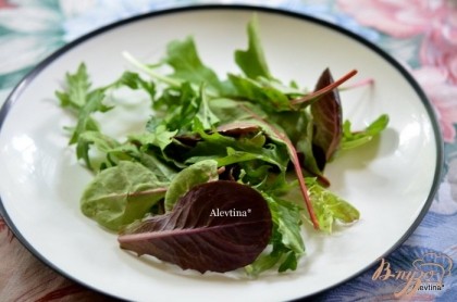 На тарелку выложить горсть салатных листьев, лук порезанный колечками тонко.