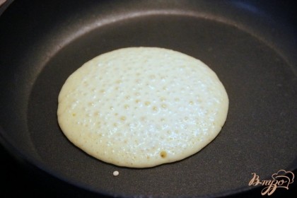 Разогреть сковороду, можно сначала смазать кисточкой жиром дно (но не обязательно), вылить по центру сковороды небольшое кол-во теста,  по 10-12 см в диаметре. Дождаться появления пузырьков на поверхности