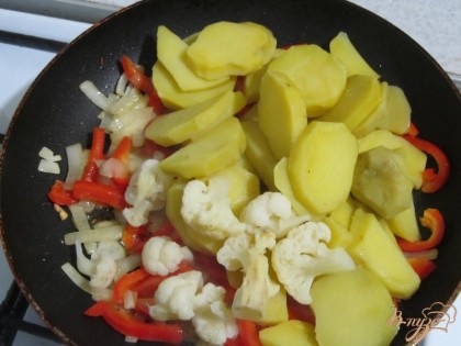 В овощную смесь введу картофель и цветную капусту. Обжарю 5 минут. Добавлю соль и перец по вкусу.