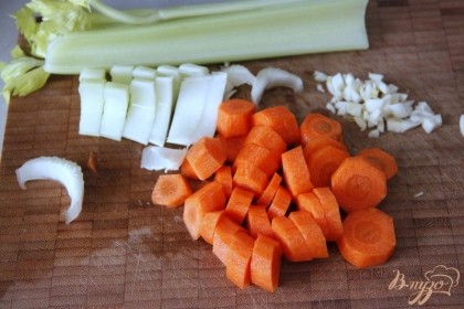 Нарезать колечками морковь,полукольцами - стебли сельдерея и очень мелко - чеснок, имбирь