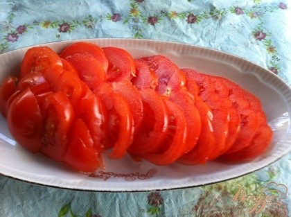 Нарезаем кружочками помидоры и выкладываем на блюдо.