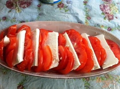 Кладем пластинку сыра между двумя кружочка помидора.
