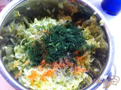 Добавляем зелень к кабачково-морковной массе,солим и перчим, выдавливаем прессом чеснок.