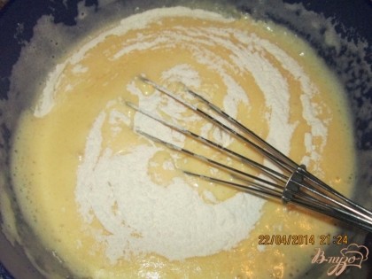  На поверхность взбитой яичной массы с сахаром добавить просеянную муку. Аккуратно перемешать тесто.