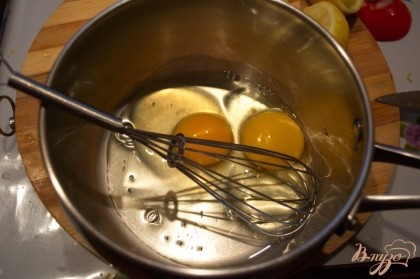 В миску вбейте 2 яйца. Добавьте лимонный сок и воду. Взбейте.