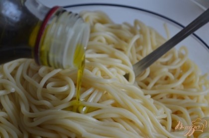 Спагетти отварить до готовности, воду слить и немного промыть .Выложить в салатник , добавить оливковое масло и перемешать.