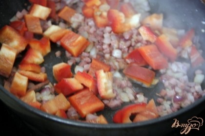 Добавить болгарский перец, нарезанный небольшими квадратиками, жарить несколько минут.