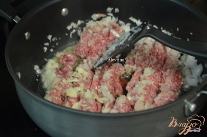 Обжарить на большой сковороде лук порезанный, добавить фарш и обжаривать до коричневого цвета. Слить жир.