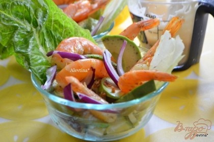 Готово! Разложим по тарелочкам салатные листья. Затем порезанный мелко огурец, лук, авокадо дольками, креветки готовые.Подаем с соусом заправкой. Приятного аппетита.
