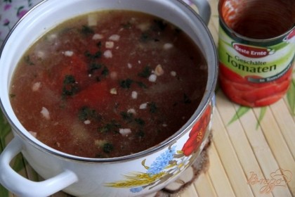 Добавить зажарку к бульону (у меня - овощной), добавить баночку томатов в собст. соку кусочками или свежие очищенные помидоры, дать супу закипеть