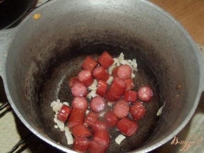В казанке растопите сало и обжарьте 2-3 минутки колбаски. Выложите их в отдельную мисочку.