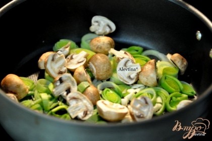 Разогреть сковороду с маслом , добавить порезанный лук порей, чеснок , грибы на пополам, тушить помешивая 10 мин.