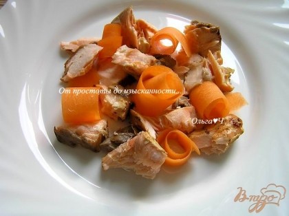 На тарелки выложить кусочки приготовленного лосося и морковь, нарезанную тонкими пластинами с помощью овощечистки.