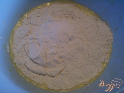 К яично-маргариновой смеси добавляем муку и соду. Смешиваем.