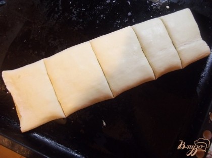 Выложите тесто на противень смазанный растительным маслом. Ножом нарежьте тесто по всей длине на квадраты шириной в 5-7 см. Так будет легче после выпекания нарезать плацинду.