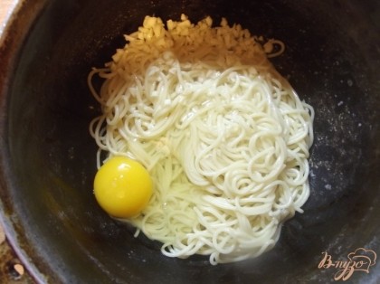 Готовые спагетти откиньте на дуршлаг и после назад в казанок. Добавьте чеснок, оливковое масло и куриное яйцо. Хорошенько перемешайте.