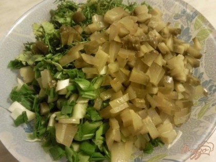 Соленые огурцы и зелень нарежем и добавим к капусте и картошке.